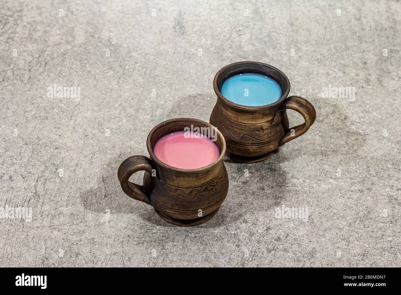 Bevanda alla moda blu e latte rosa. Lavanda o spirulina e rosè, barbabietole o caffè di lamponi. Pietra sfondo cemento, copia spazio Foto Stock