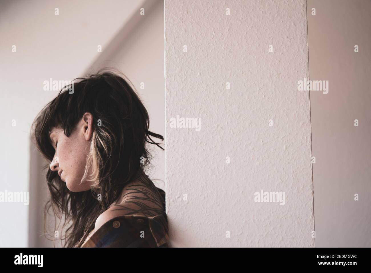 donna naturale con capelli ricci ha momento tranquillo nella luce della finestra Foto Stock