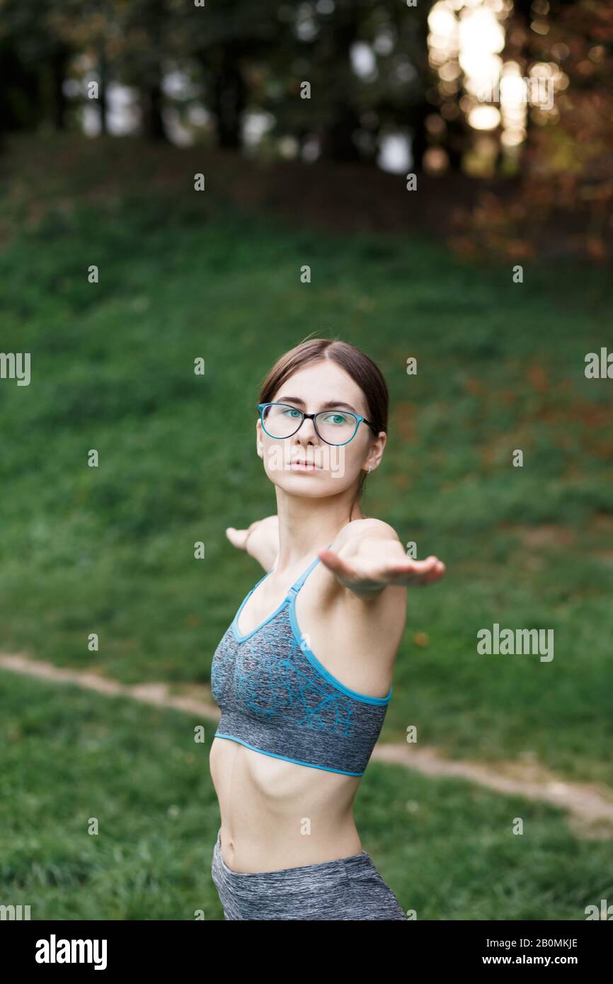 La ragazza rilassata sta facendo yoga nel parco su tappeto Foto Stock
