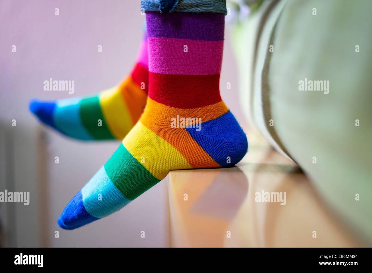 Piedi con orgoglio e calze colorate sul letto. Concetto di calze a letto. Foto Stock