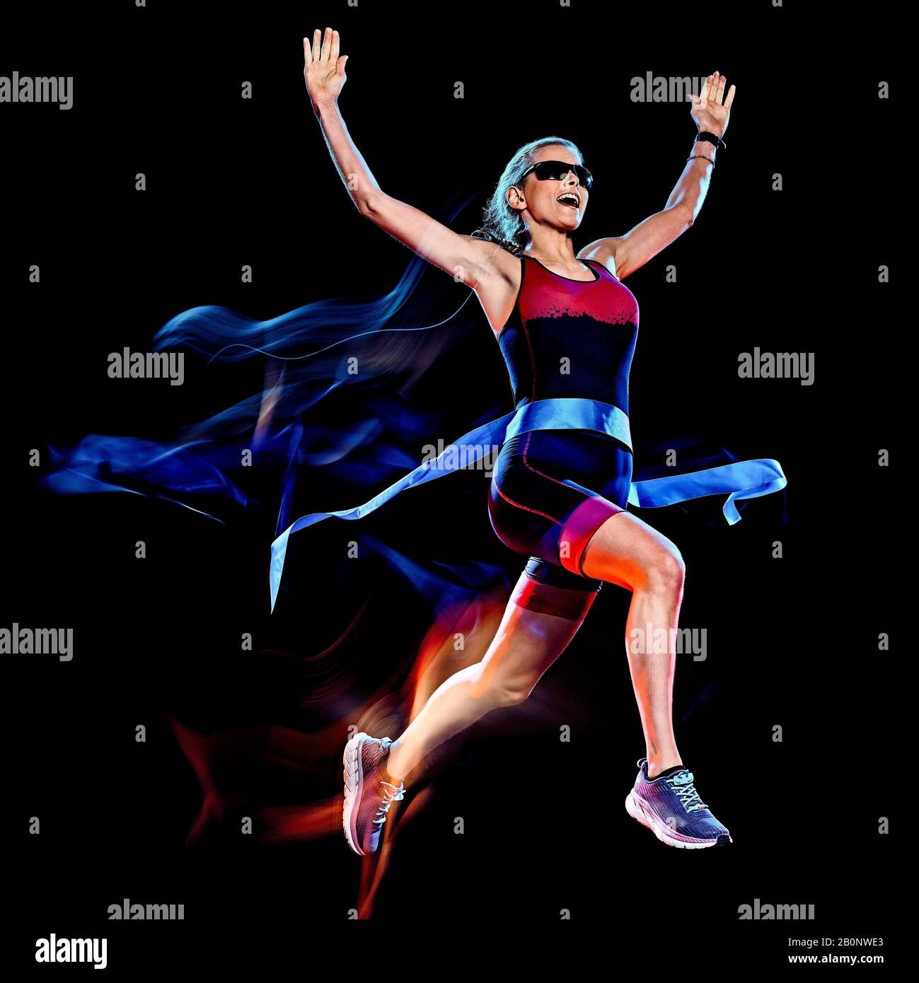 Una donna caucasica triathlon triatleta runner acceso joogger jogging studio shot isolato su sfondo nero con leggero effetto di pittura Foto Stock