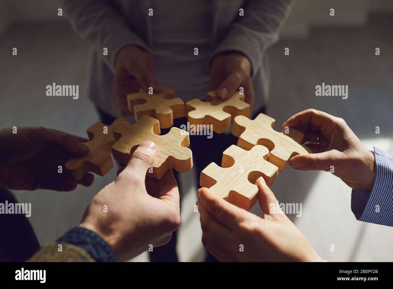 Crop colleghi idea impilare puzzle di legno insieme Foto Stock