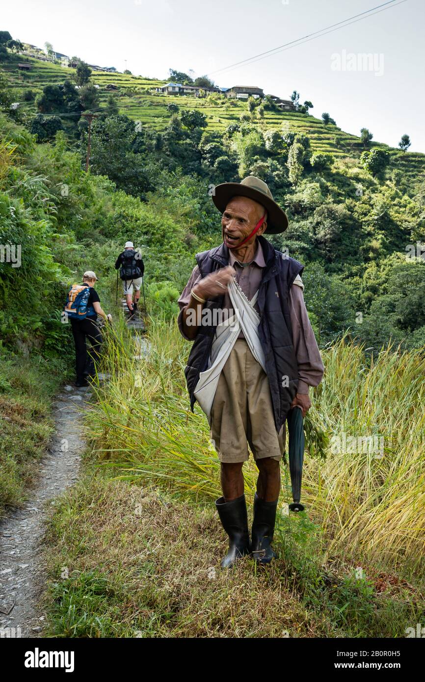 Uomo nepalese in abbigliamento tradizionale sul sentiero di montagna himalayano Foto Stock