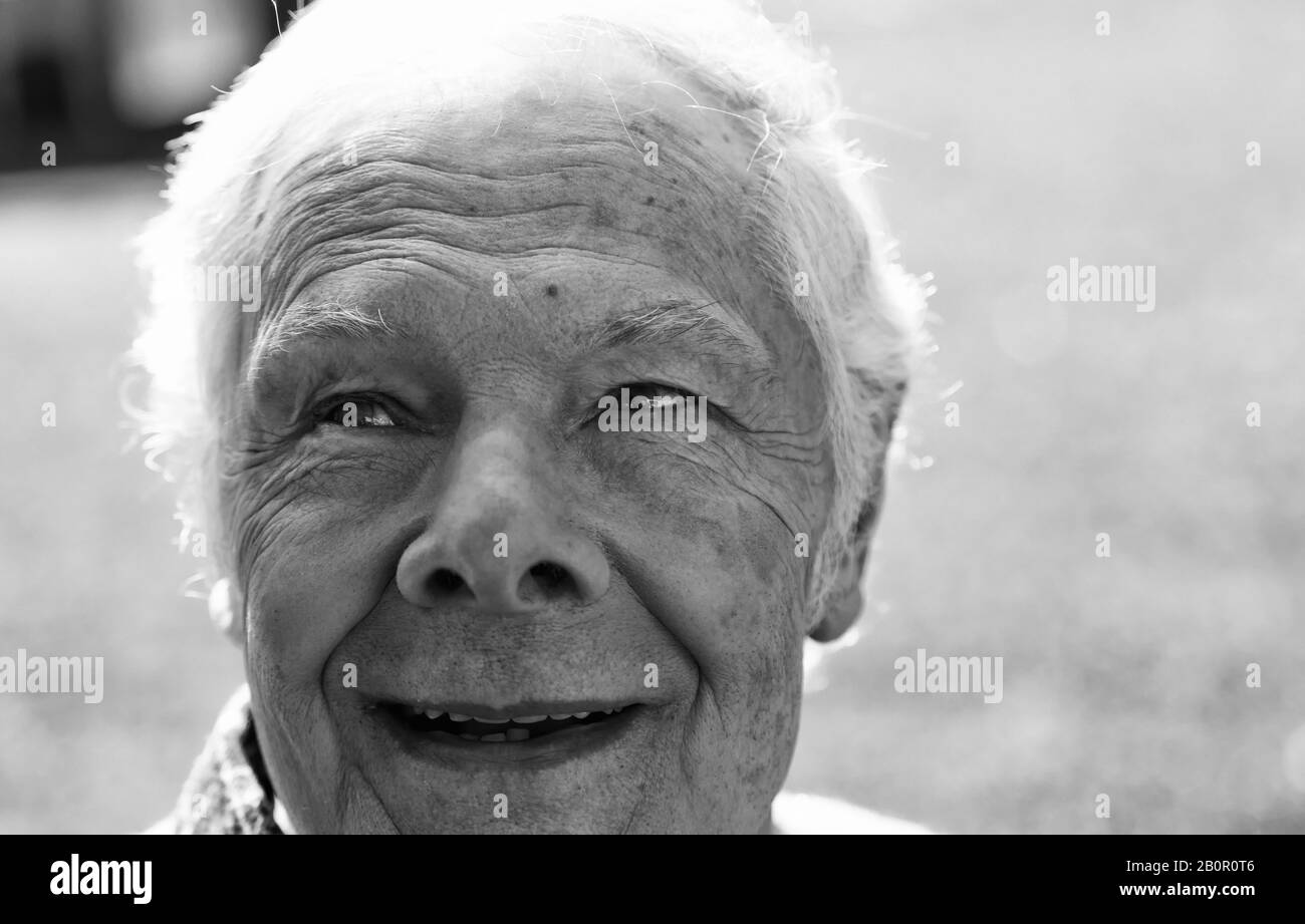 Felice espressione del volto dell'uomo anziano nel giardino. Foto Stock