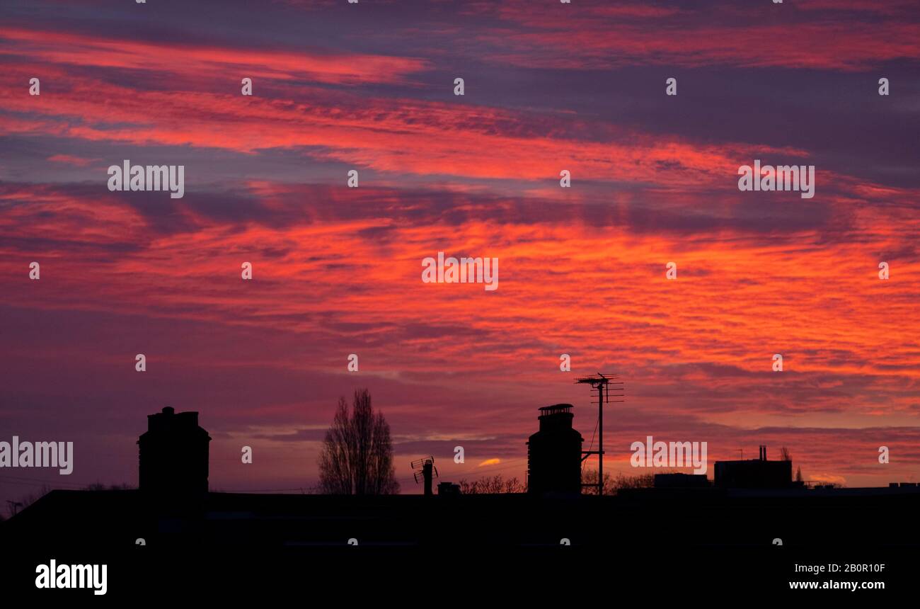 Wimbledon, Londra, Regno Unito. 21st febbraio 2020. I tetti si stagliano contro un cielo rosso brillante prima dell'alba nella Londra sud-occidentale. Credito: Malcolm Park/Alamy Live News. Foto Stock