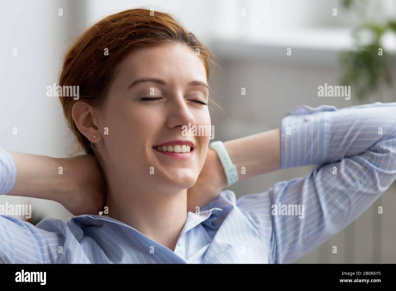 Primo piano sorridente businesswoman rilassarsi in sedia confortevole dopo il lavoro finito sul posto di lavoro, sognando di buon futuro, la visualizzazione, soddisfatto Foto Stock