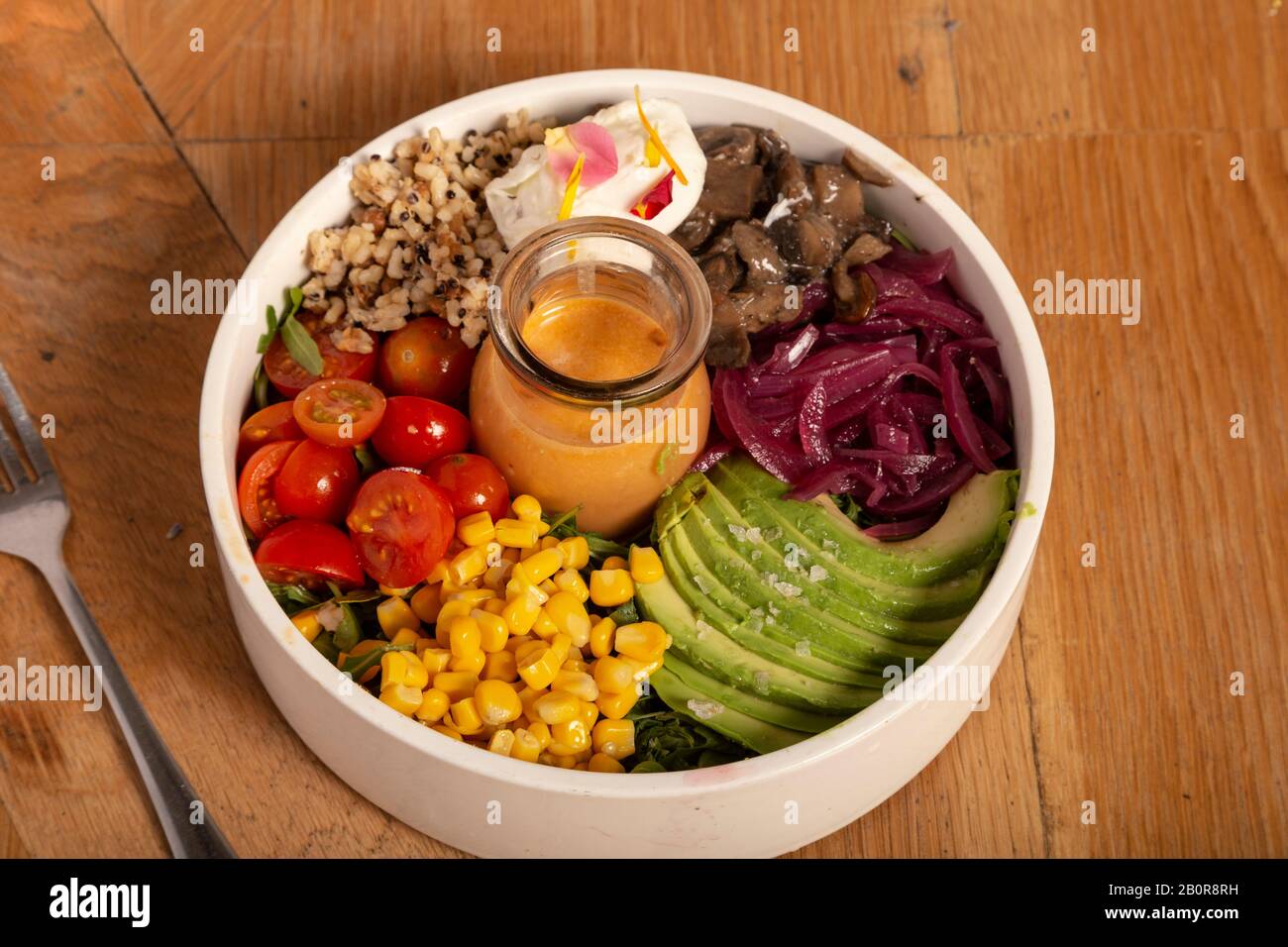 Insalata con prodotti biologici di pomodori ciliegini, mais, avocado, barbabietole e quinoa. Cibo sano. Foto Stock