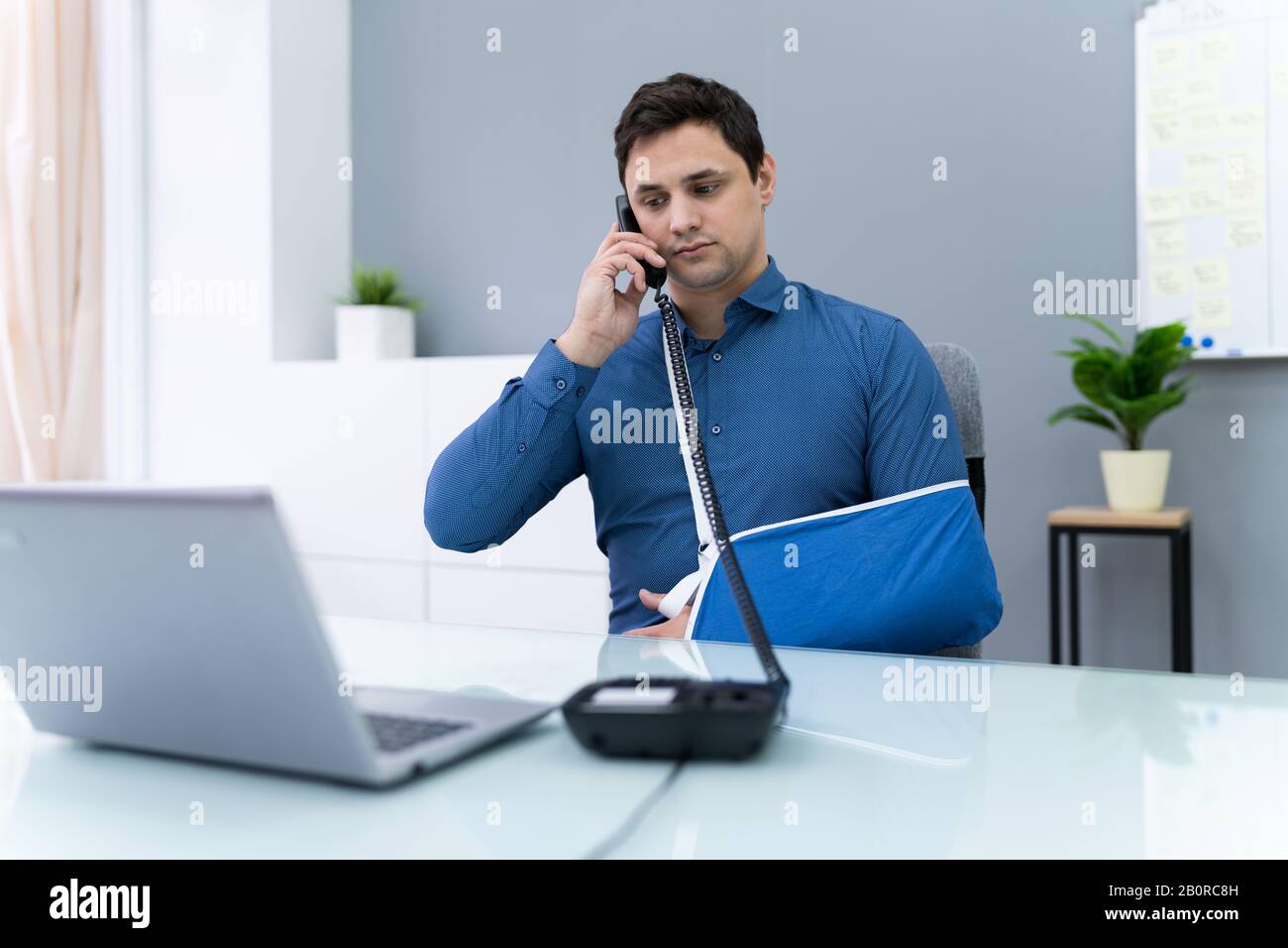 Uomo D'Affari Con Disabilità Che Lavora In Ufficio Chiamando Al Telefono Foto Stock