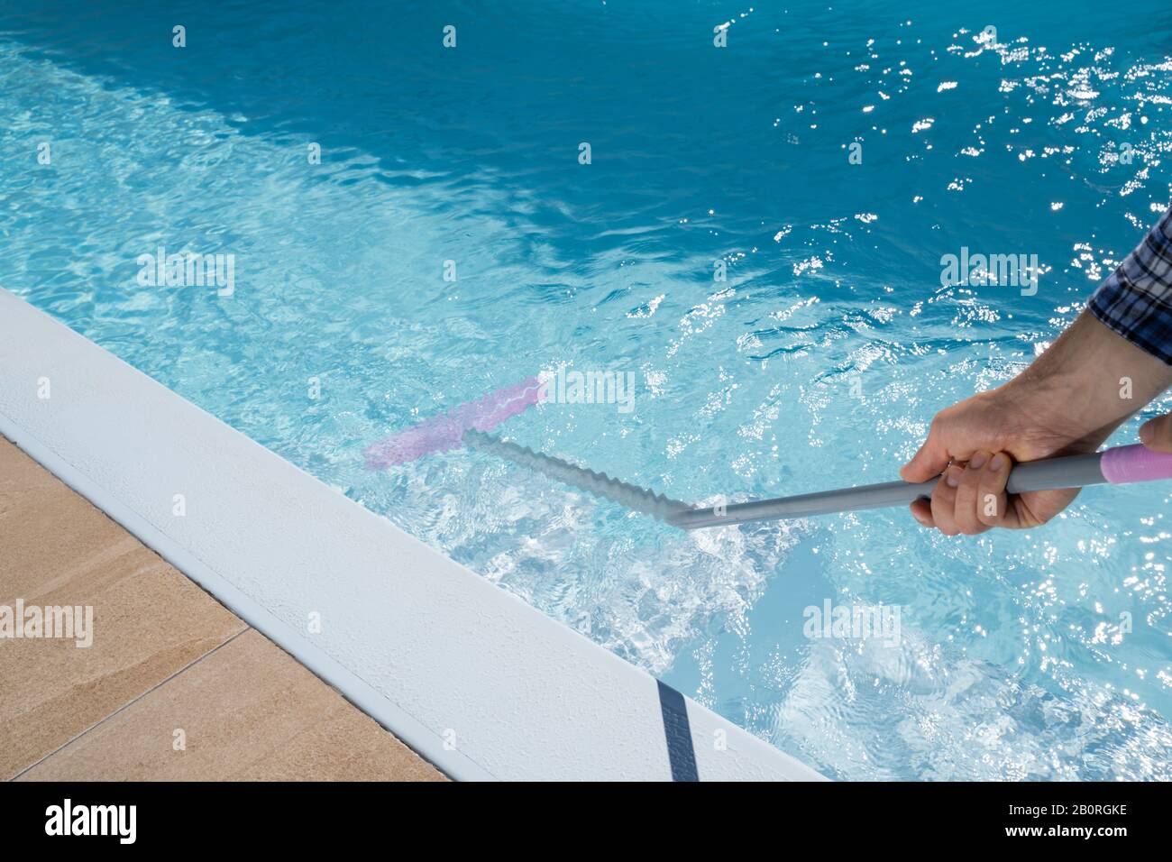 Lavoratore Maschile In Uniforme Pulizia Piscina Foto Stock