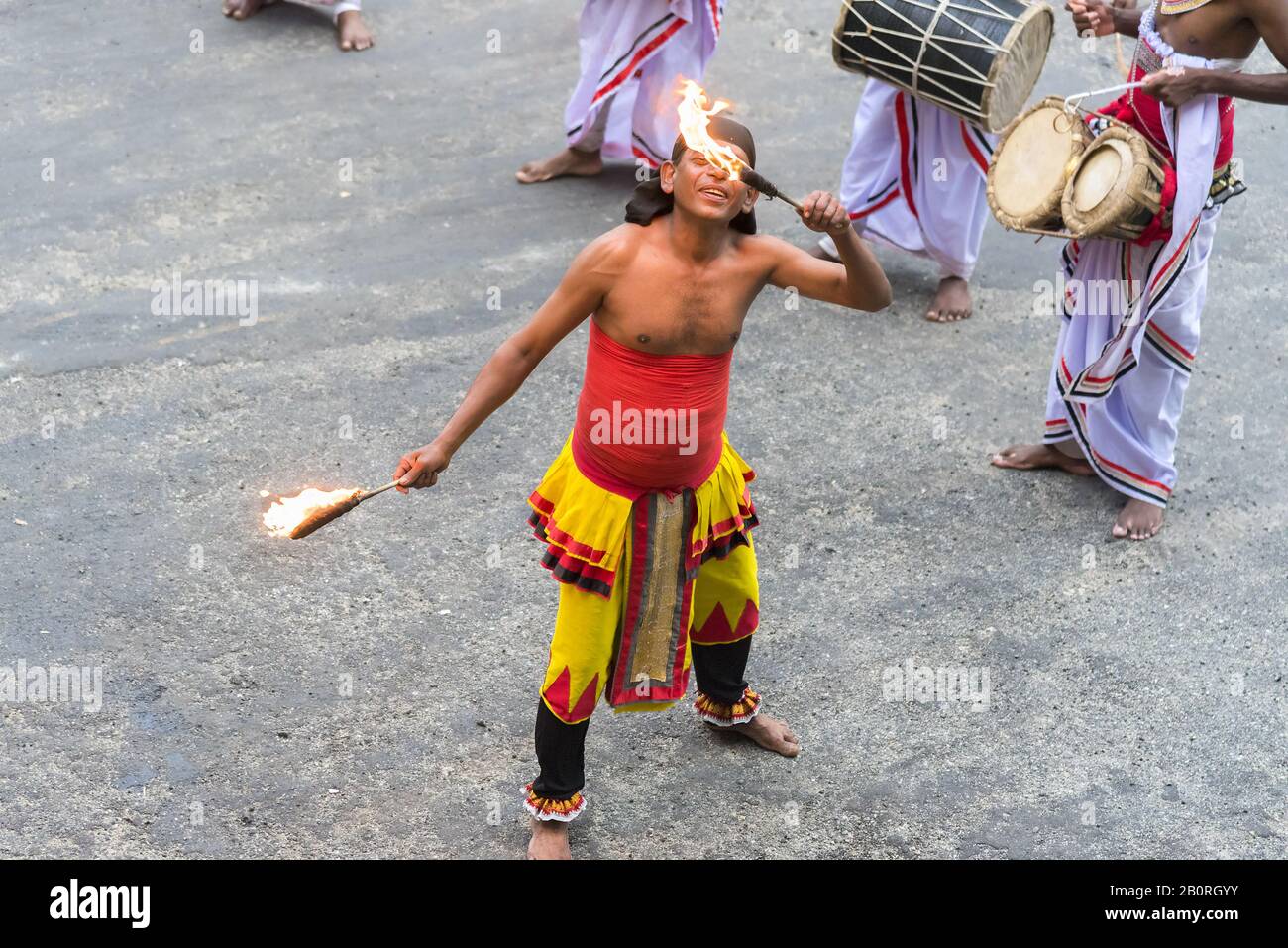 MATALE, Sri Lanka: 18/03/2019: Mangiatore di fuoco che insegue i turisti con una mostra di tamburi e mangiando fuoco. Foto Stock