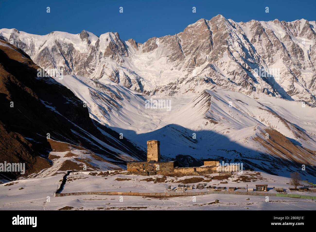 Torre di guardia di fronte ad un paesaggio di montagna, Ushguli, Svanetia superiore, Georgia Foto Stock