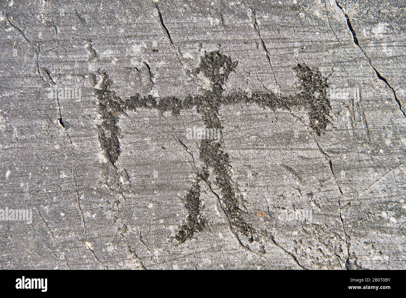 Petroglyph, scultura in roccia, di figura umana schematica con un foglio e arma. Scolpito dagli antichi Camuni nell'età del tardo Gopper tra il 2400 Foto Stock