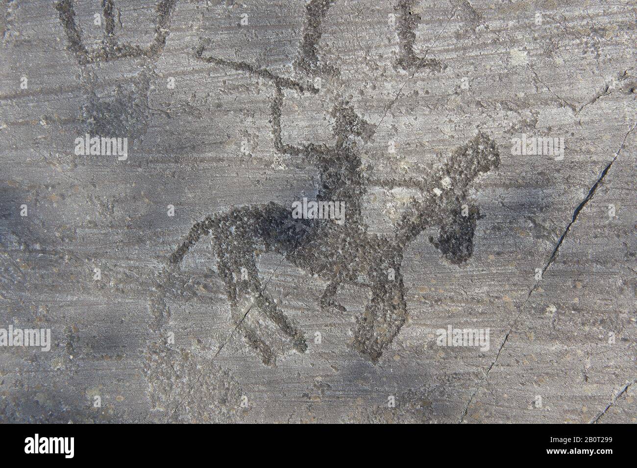 Petroglyph, scultura in roccia, di un guerriero a cavallo con una ascia quadrangolare e merlato scolpito dall'antico popolo Camuni nell'età del ferro tra il 900-1 Foto Stock