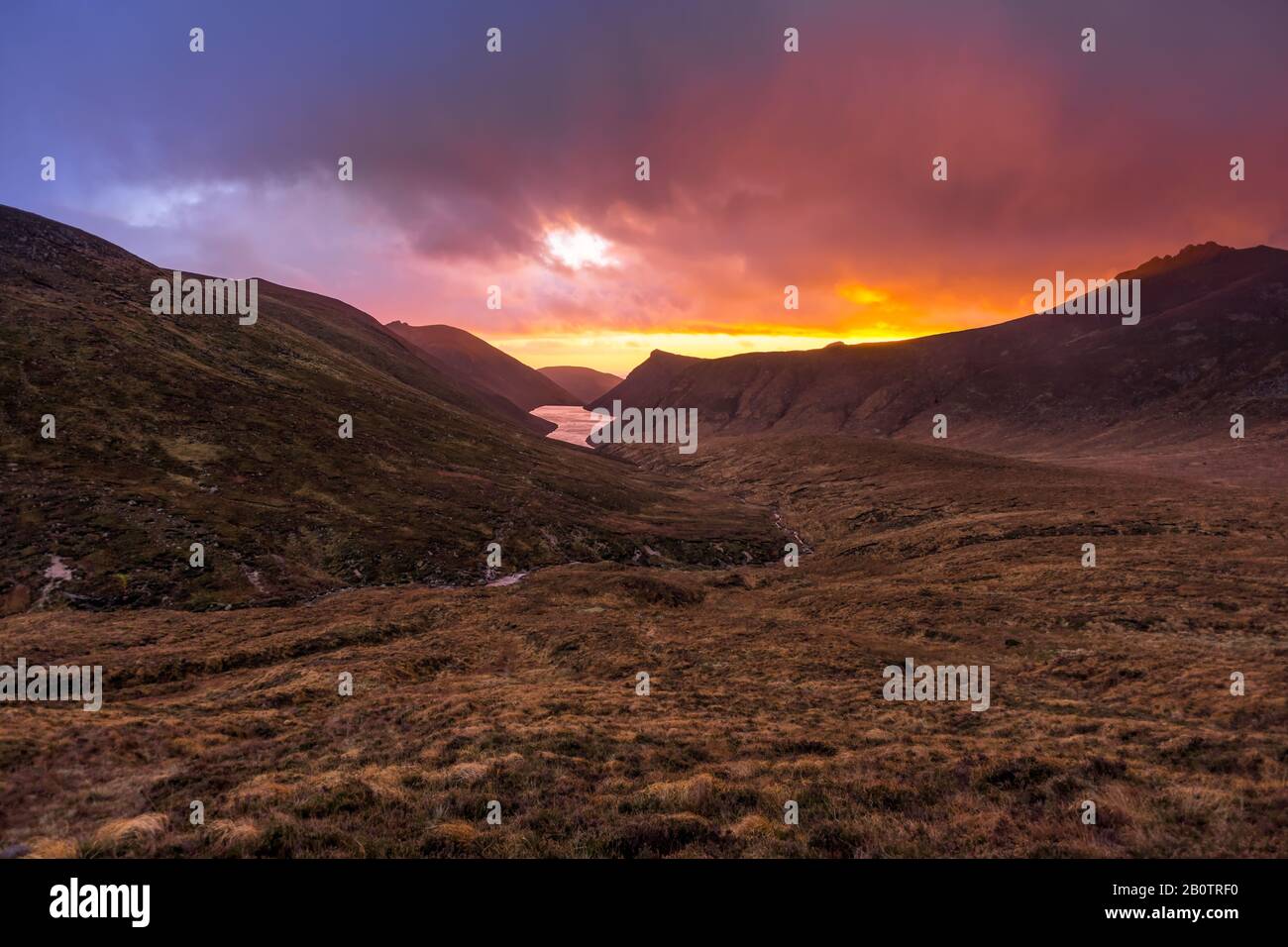 Bella valle con serbatoio d'acqua nelle montagne Mourne a ore d'oro e suggestivo tramonto. Mourne Mountains, la catena più alta dell'Irlanda del Nord Foto Stock