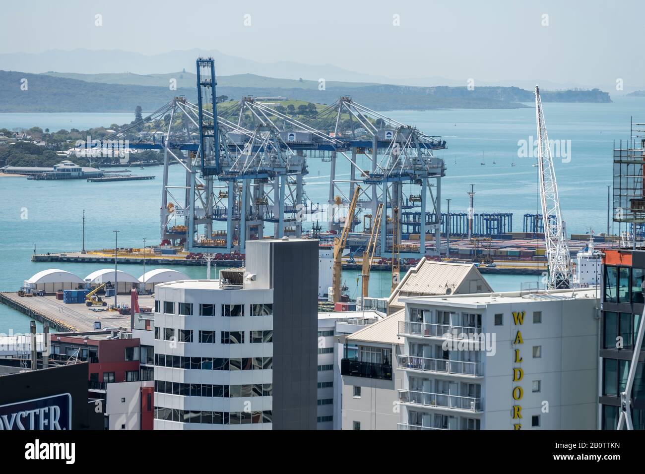 Auckland, NUOVA ZELANDA - 05 novembre 2019: Paesaggio urbano dall'alto di grandi gru portuali e di edifici alti nel fresco centro della città dinamica, girato a Brigh Foto Stock