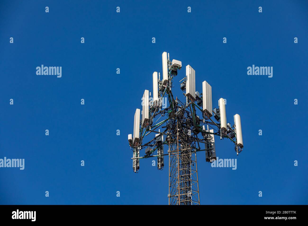 Antenna tower per telefoni cellulari wireless. Apparecchiature di telecomunicazione isolate su sfondo blu cielo. Concetto di area di copertura della tecnologia di comunicazione Foto Stock