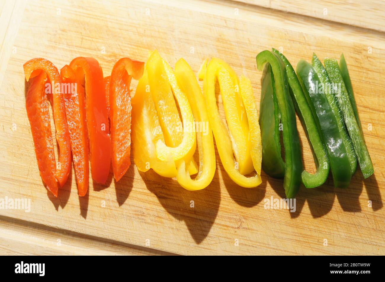 Peperoni a colori misti tritati su tagliere Foto Stock
