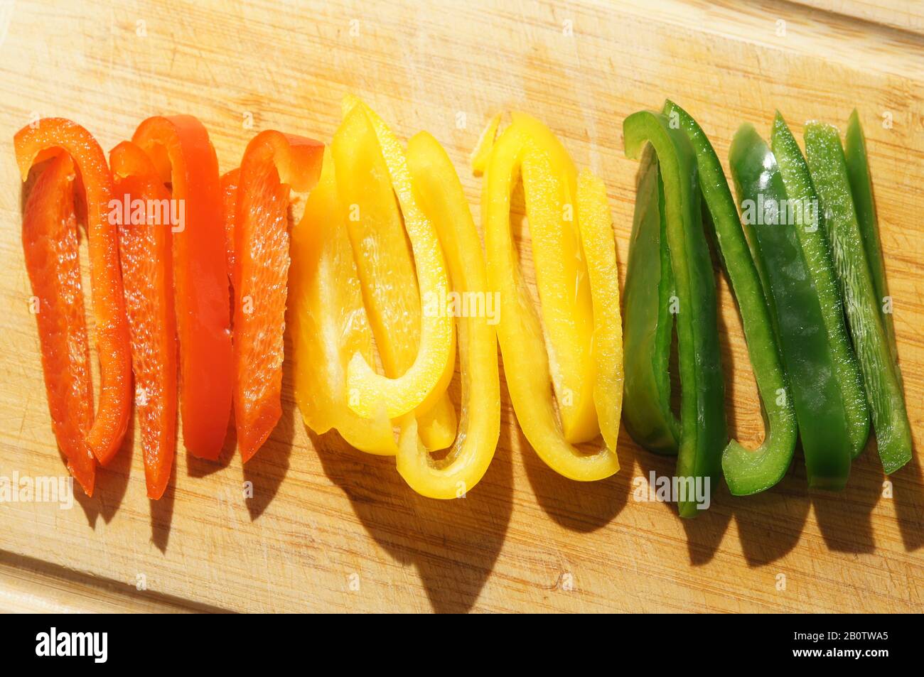 Peperoni a colori misti tritati su tagliere Foto Stock