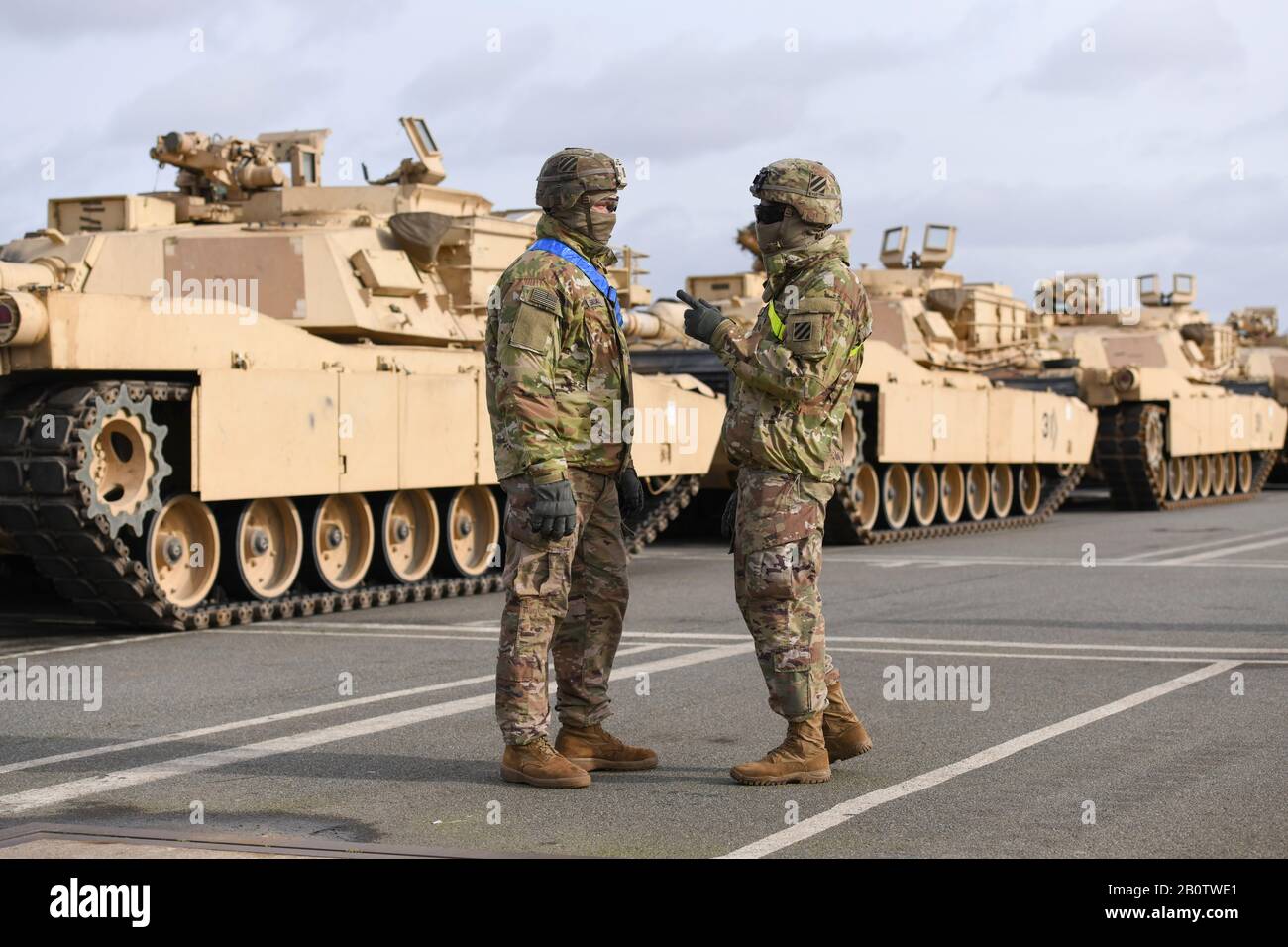 2 dicembre 2019, Brema, Bremerhaven: I veicoli cingolati e gommati dell'esercito americano vengono scaricati a Bremerhaven come parte dell'esercizio principale "Defender Europe 20" e sorvegliati da due soldati statunitensi. Foto: Karsten Klama/Dpa Foto Stock