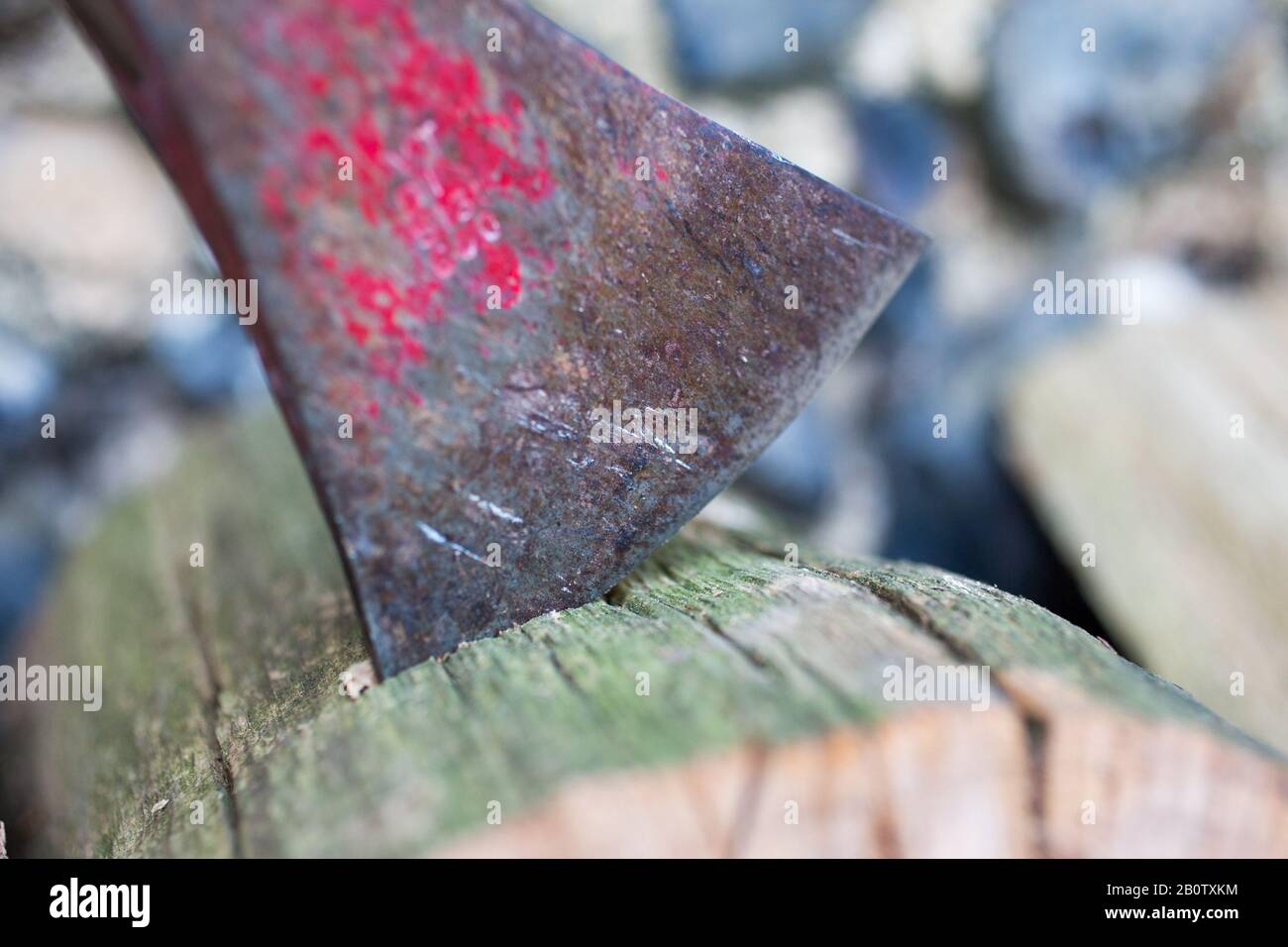 L'immagine mostra un'ascia pronta a tagliare il legno per un incendio. I proprietari di bruciatori di legno, stufe e fuochi aperti non potranno più comprare carbone o legno umido per bruciare in loro, sotto un divieto di essere rotolato fuori dall'anno prossimo. Le vendite dei due combustibili più inquinanti saranno gradualmente eliminate in Inghilterra per contribuire a ridurre l'inquinamento atmosferico, afferma il governo. Sacchetti di tronchi venduti in negozi fai da te, centri giardino e stazioni di servizio spesso contengono legno umido - un tipo di legno che produce più inquinamento e fumo. Il pubblico dovrebbe passare a "alternative più pulite", afferma il governo. Foto Stock