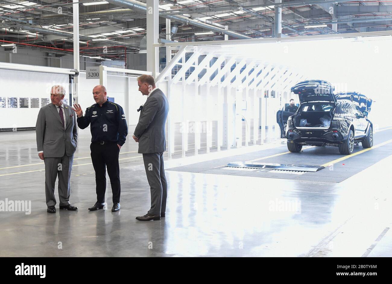 Il Principe di Galles (a sinistra) parla con il personale durante una visita alla nuova fabbrica Aston Martin Lagonda di Barry, Galles. Foto Stock