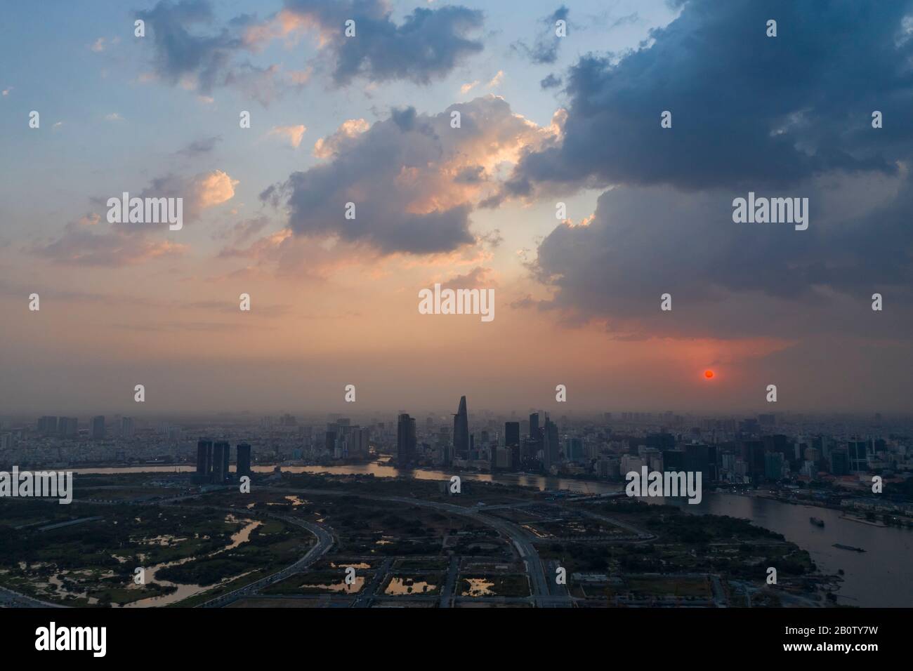 Spettacolare vista aerea del fiume Saigon e dello skyline di ho Chi Minh al tramonto con splendide nuvole tempestose e dai colori vivaci nel cielo Foto Stock