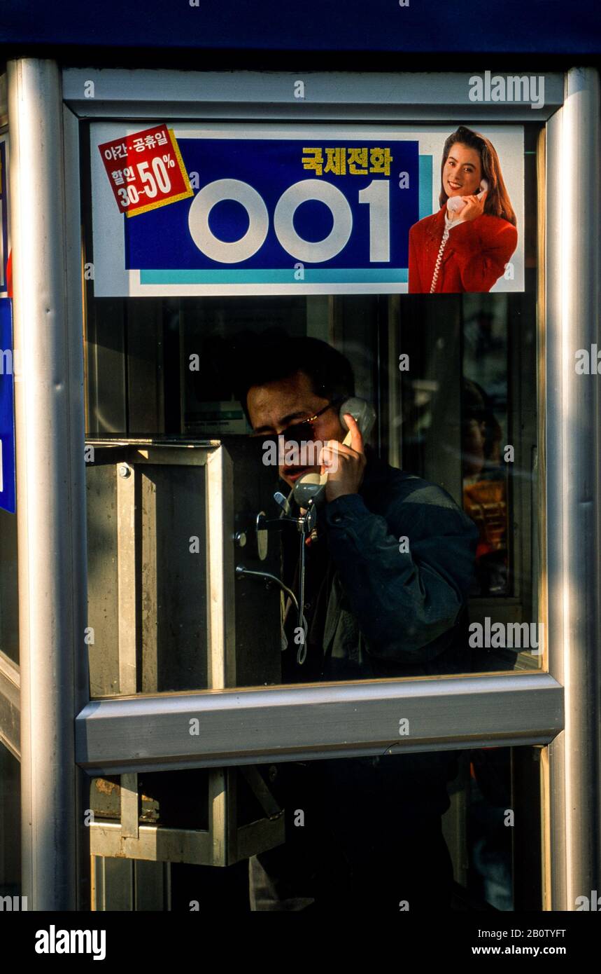 Uomo in una scatola telefonica fare una chiamata, Seoul, Corea del Sud, aprile 1998 Foto Stock