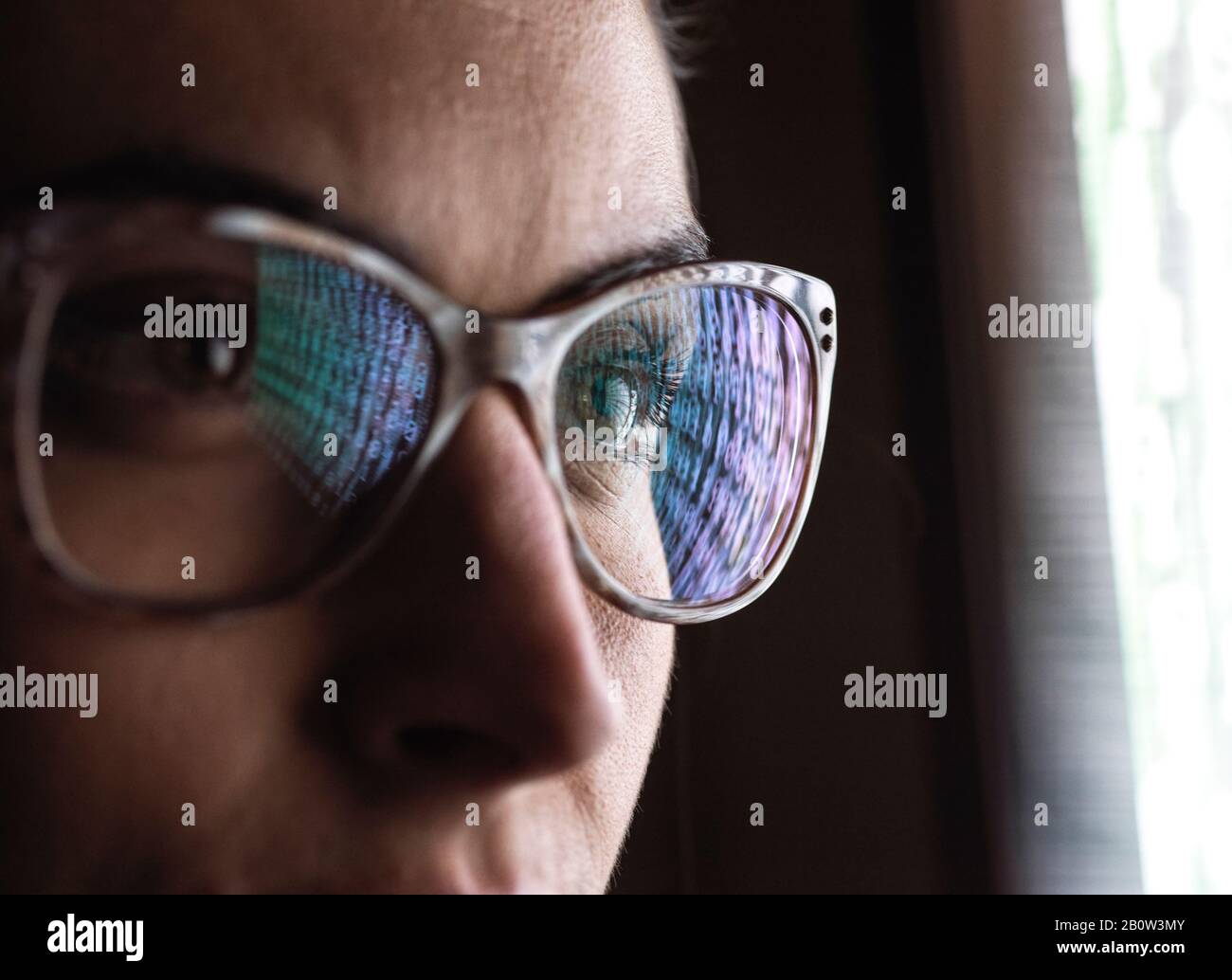 Analista dati femminile che guarda i dati sullo schermo, la riflessione in occhiali. Foto Stock