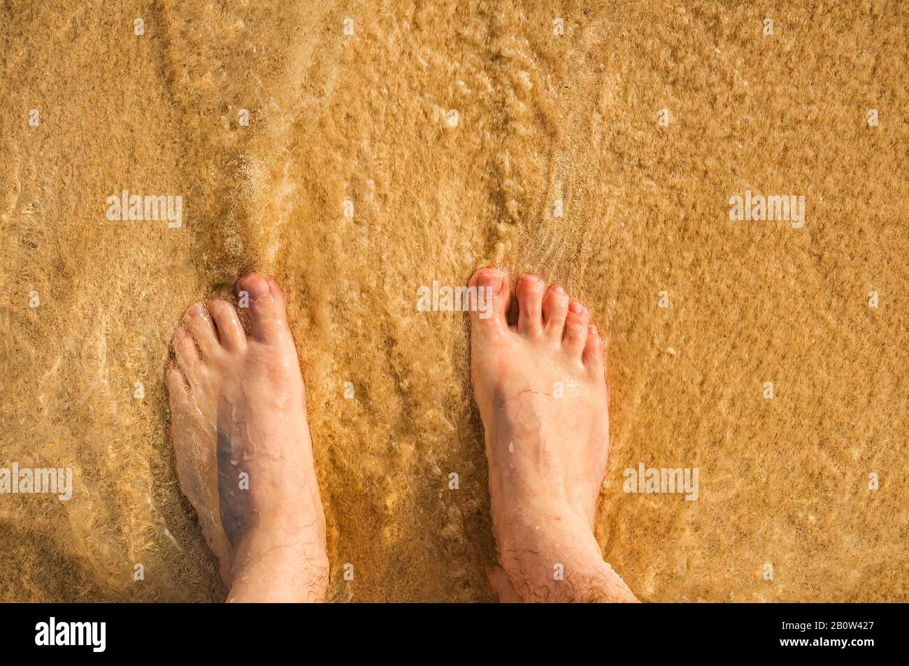 Piedi in onde sulla spiaggia, Punta Cana; Repubblica Dominicana; Caraibi; Foto Stock