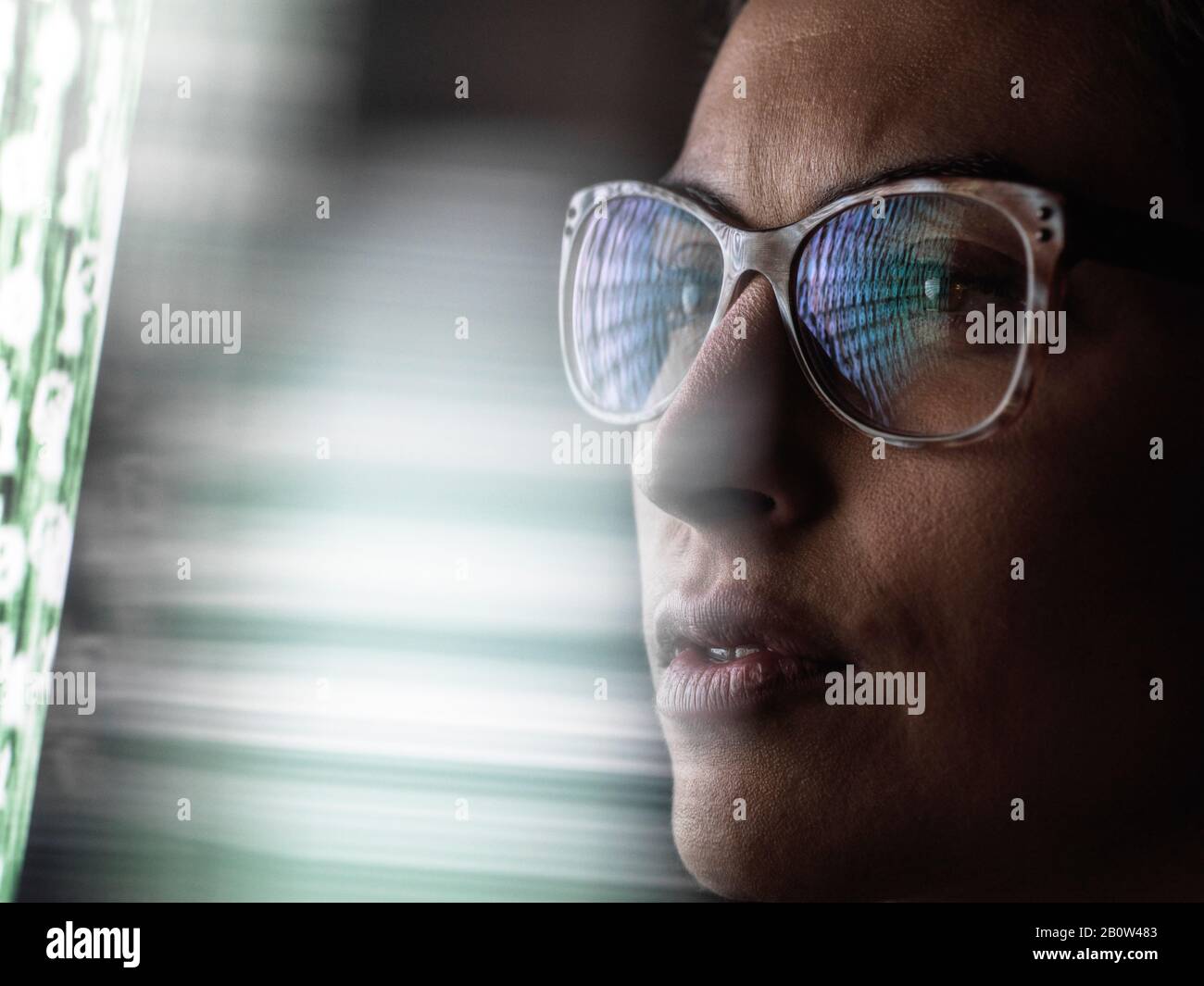 Analista dati femminile che guarda i dati sullo schermo, la riflessione in occhiali. Foto Stock