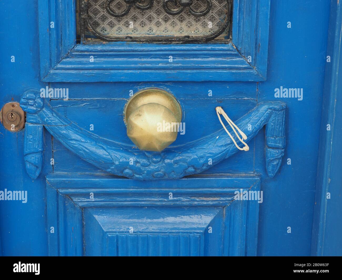 Vecchia porta in legno, intagliata, dipinta di blu con maniglia e serratura in ottone, a Citera, Grecia Foto Stock