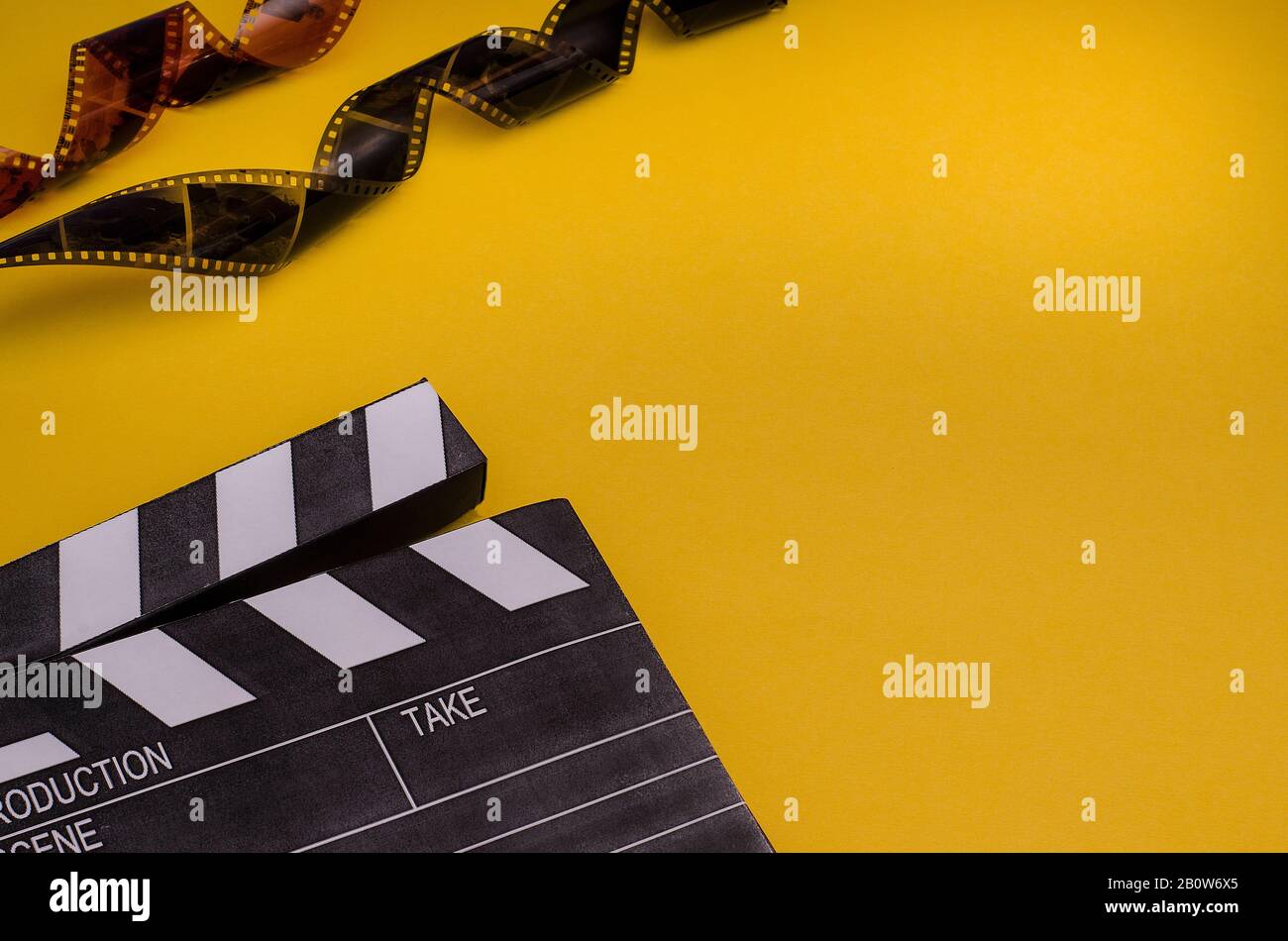 Lavagna e striscia di pellicola su sfondo giallo brillante con spazio di  copia. Per articoli sul film. Concetto di cinema Foto stock - Alamy