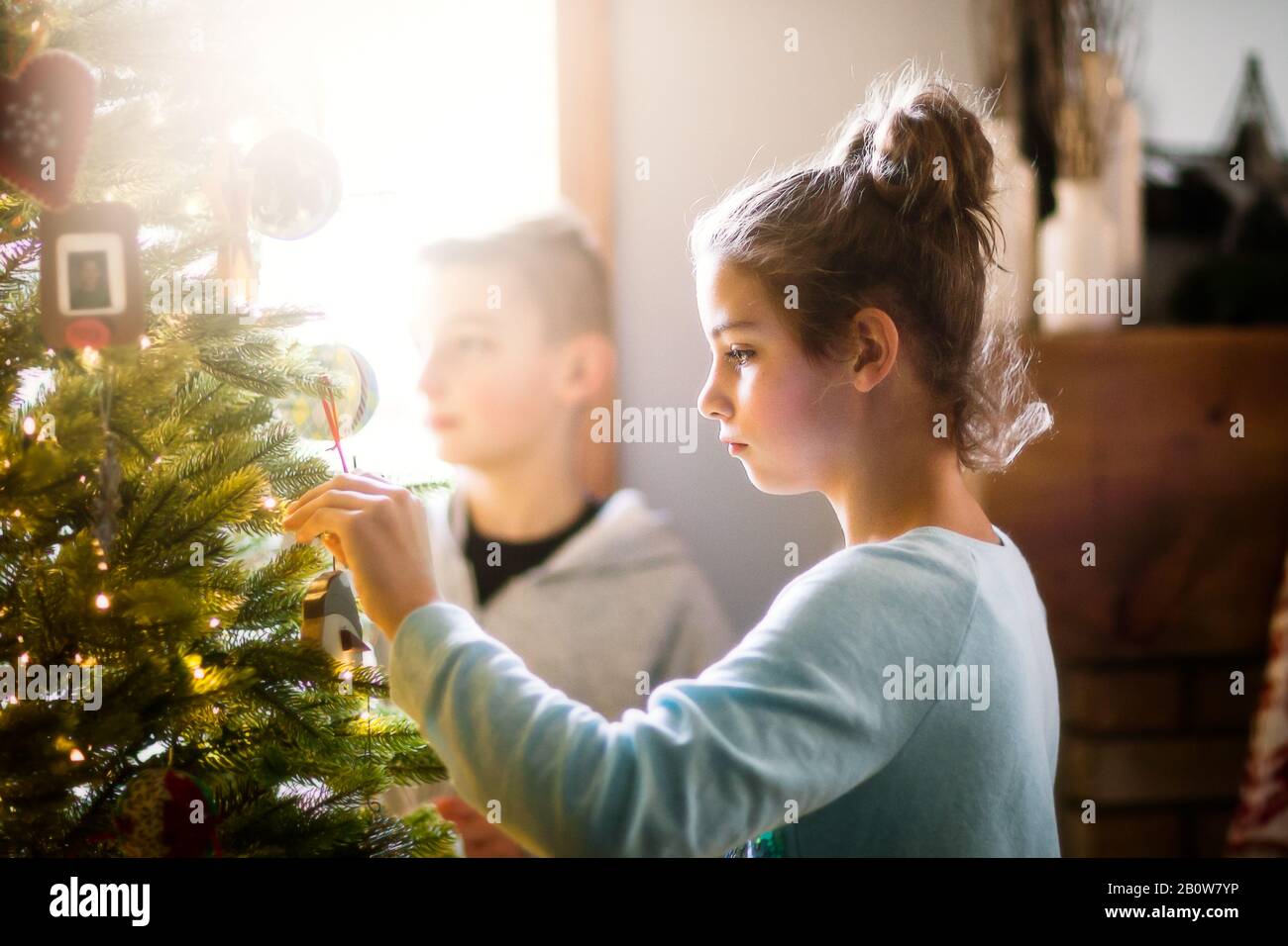 I fratelli decorare albero di Natale a casa Foto Stock