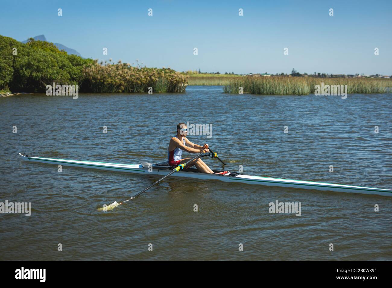 Uomo caucasico addestrando una barca a remi Foto Stock