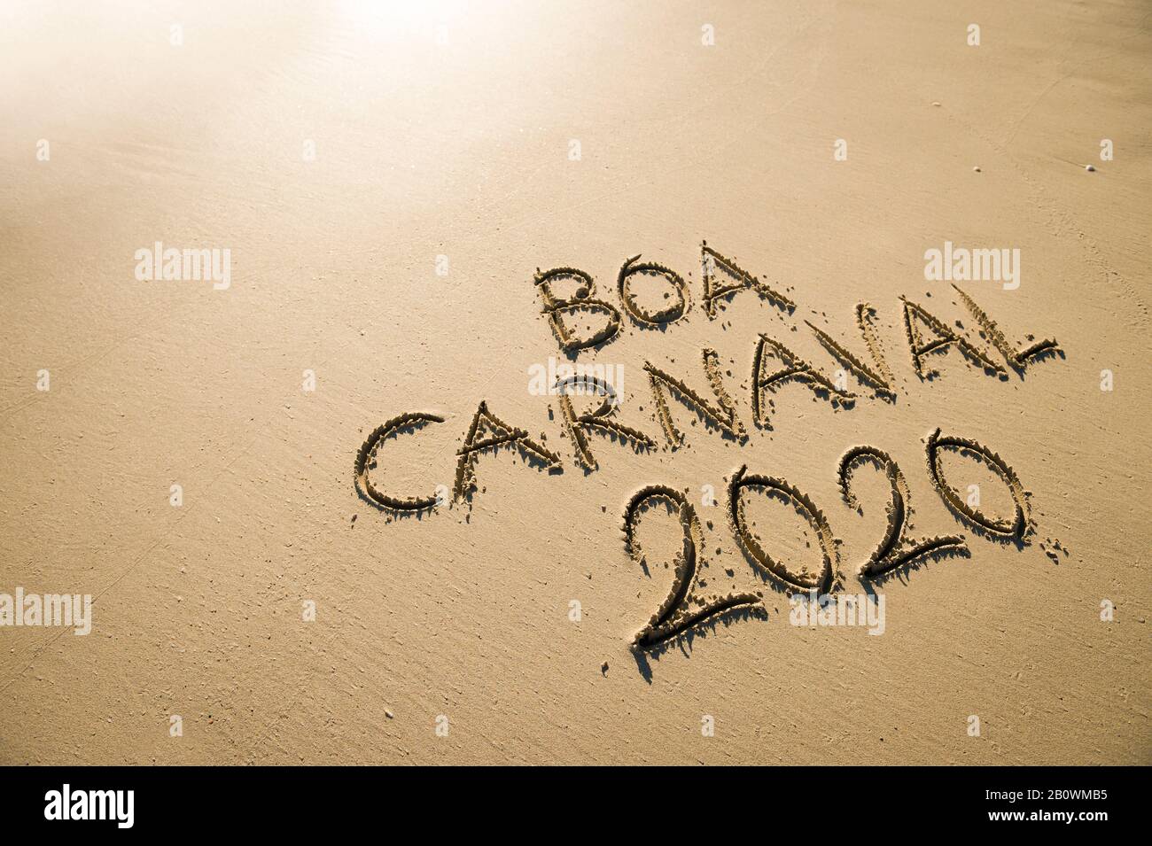 Messaggio Boa Carnaval 2020, portoghese per il Carnevale Felice, scritto a mano su spiaggia di sabbia liscia a Rio de Janeiro, Brasile Foto Stock