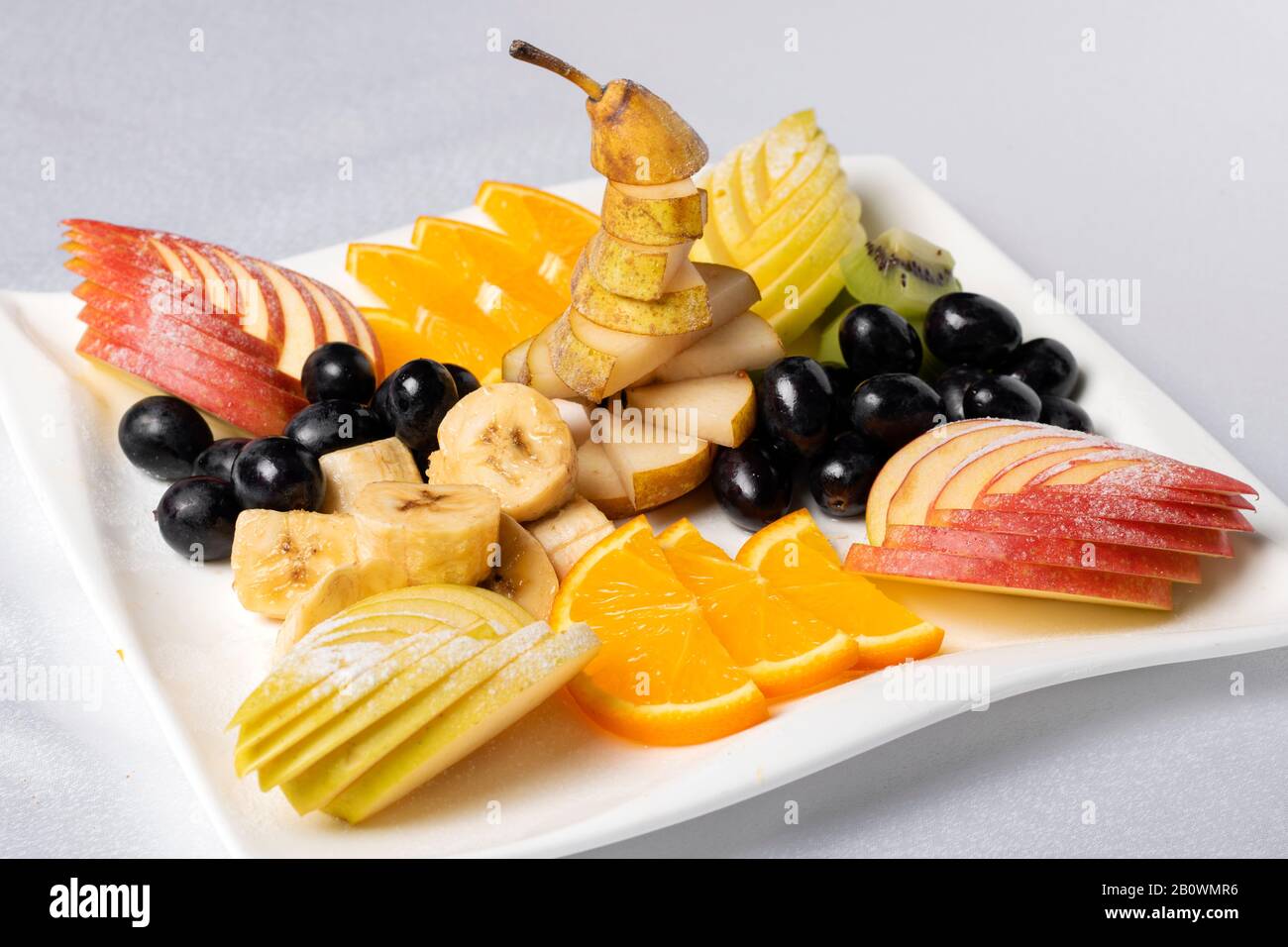 Scultura Frutta concetto. Vista dall'alto di un'insalata di frutta con fragole, arance, kiwi, mirtilli e pesche Foto Stock