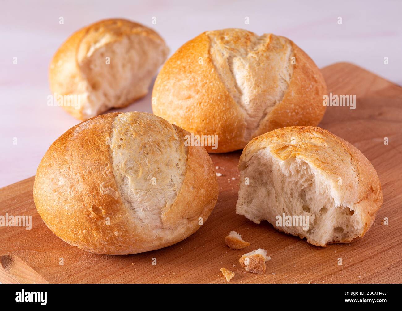 Mini focacce di pane artigianale con pasta di pane su un tagliere in legno Foto Stock