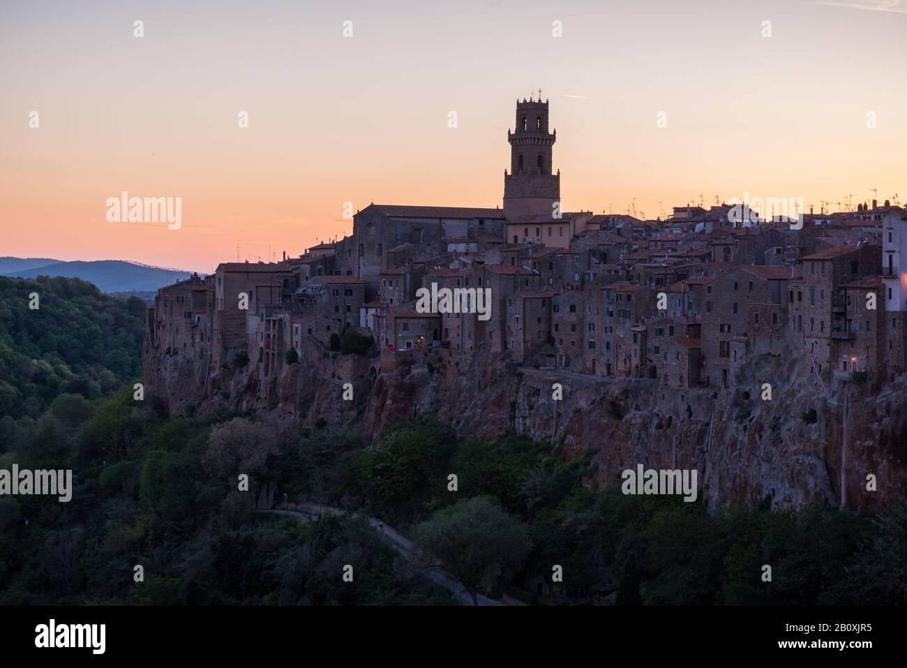 Vista panoramica di Pitigliano in Italia con case in mattoni rossi e torri al tramonto in Toscana al tramonto Foto Stock