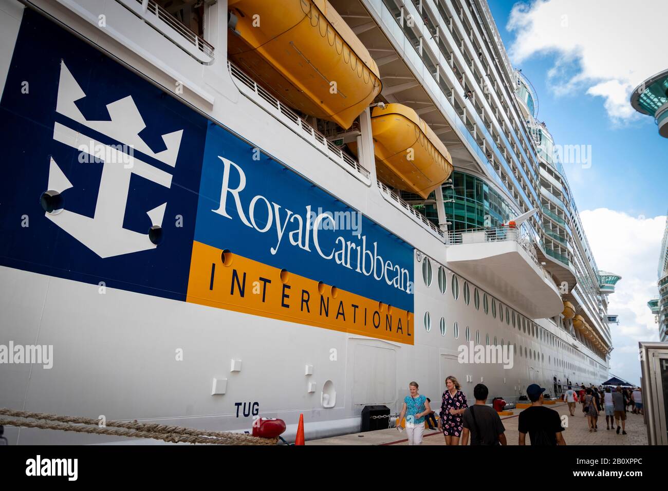 Turisti in vacanza a piedi da e per le loro navi da crociera al porto; logo 'Royal Caribbean International' nave da crociera visibile in lontananza Foto Stock