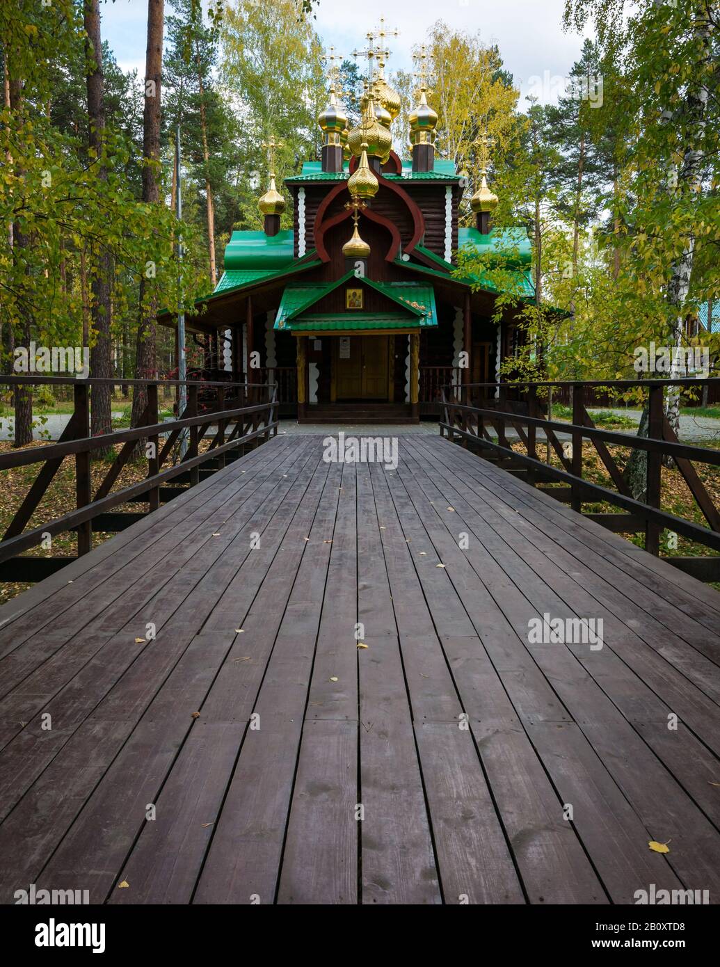 Cappella in legno con guglie d'oro e ponte pedonale. Ganina Yama, Monastero Dei Bearers Della Passione Imperiale, Siberia, Federazione Russa Foto Stock