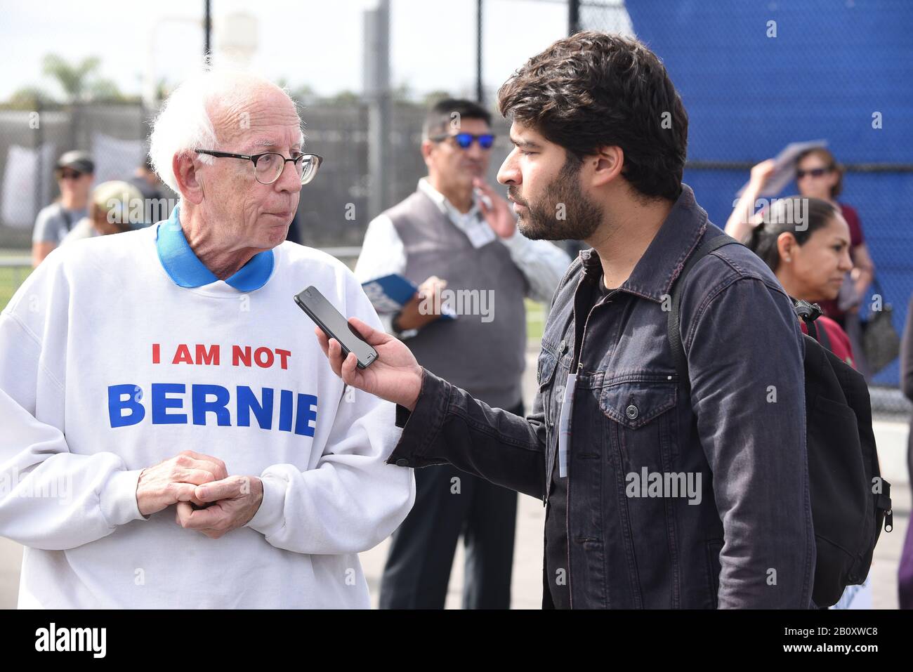 Santa ANA, CALIFORNIA - 21 FEB 2020: Bernie Sanders Rally. Intervistatore che parla con un Sanders e Larry David guardare-tanto ad un rally all'aperto. Foto Stock