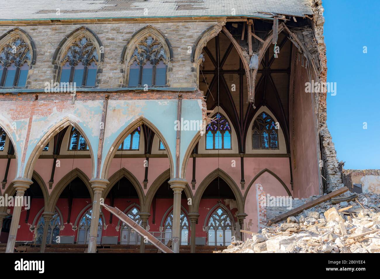 Rovine di una chiesa gotica in fase di demolizione. Gran parte della parete di fronte allo spettatore è mancante, la parete interna sull'altro lato è visibile.UN po 'di blu timido Foto Stock