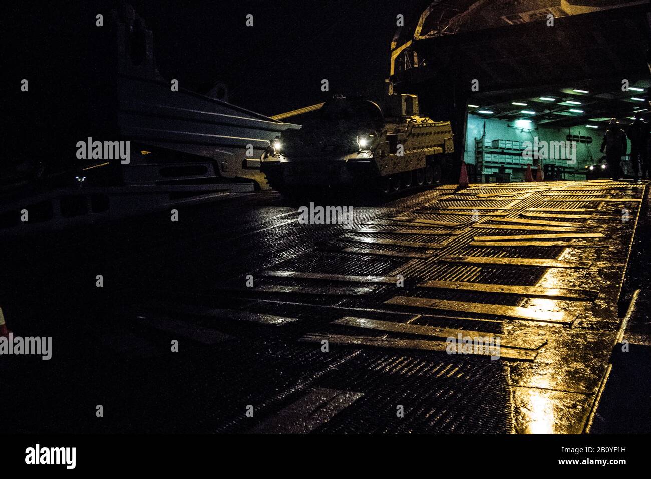 Soldati, civili e appaltatori tedeschi lavorano diligentemente durante la notte per ispezionare e trasferire le attrezzature militari dalla nave ARK Endurance dopo il suo arrivo al porto di Bremerhaven, Germania, il 20th febbraio. L'apparecchiatura verrà portata in più sedi a supporto di Defender Europe 20. (Foto US Army di Sgt. Dommnique Washington, 7th Mobile Affari Pubblici Distacco) Foto Stock
