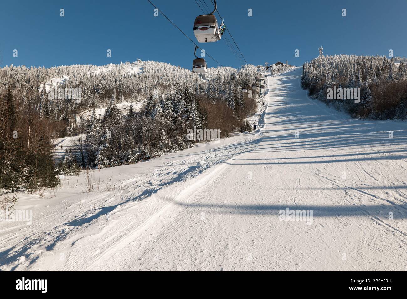 vista della cabinovia con montagne innevate, gondola sopra la pista da sci Foto Stock