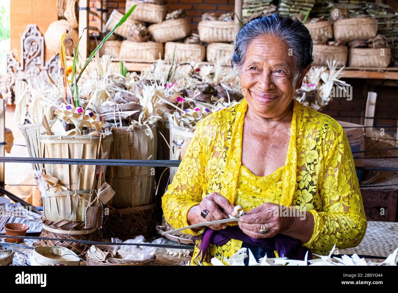 Vecchia donna che si prepara per un festival a Canggu, Indonesia. Luglio 2016 Foto Stock