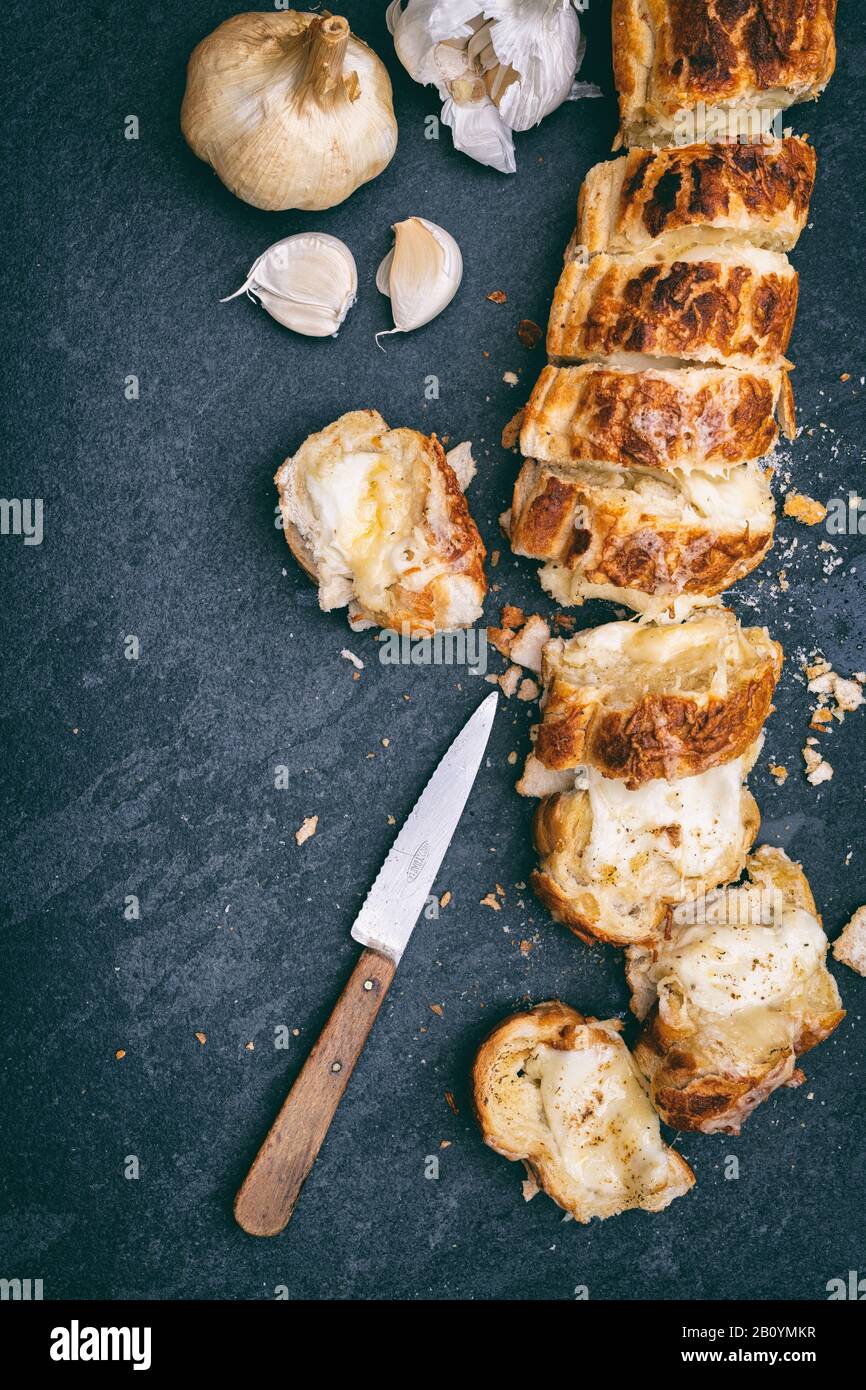 Pane francese all'aglio fatto in casa e formaggio fuso su uno sfondo di ardesia Foto Stock