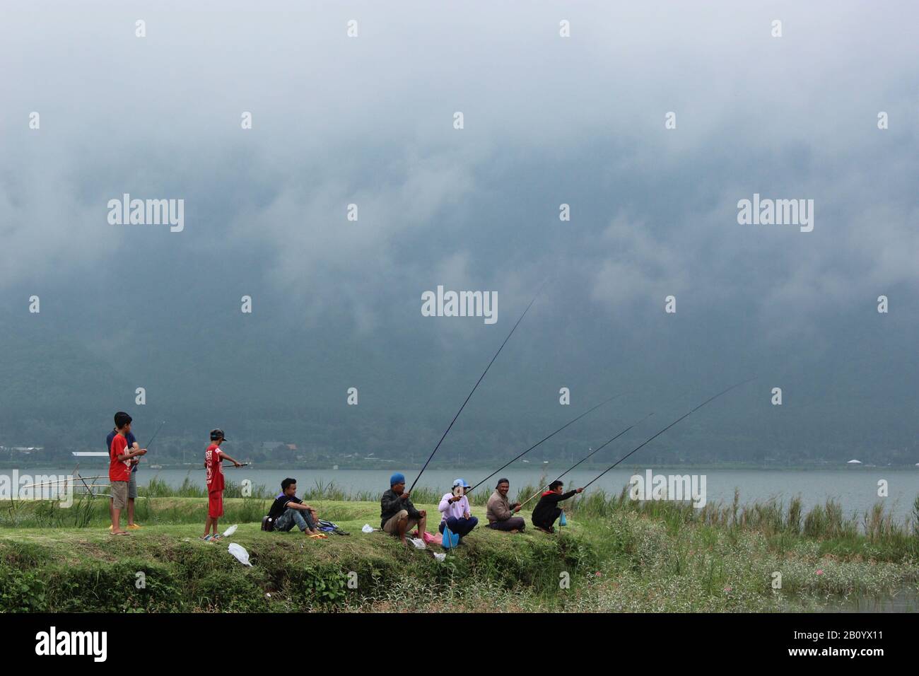 La gente del posto sta pescando al lago Beratan, Bali Foto Stock