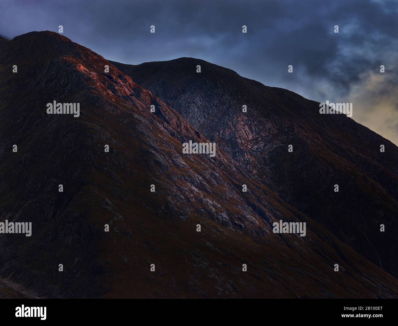 L'ultima sera la luce colpisce una roccia nelle Highlands scozzesi, Glen Coe, Scozia Foto Stock