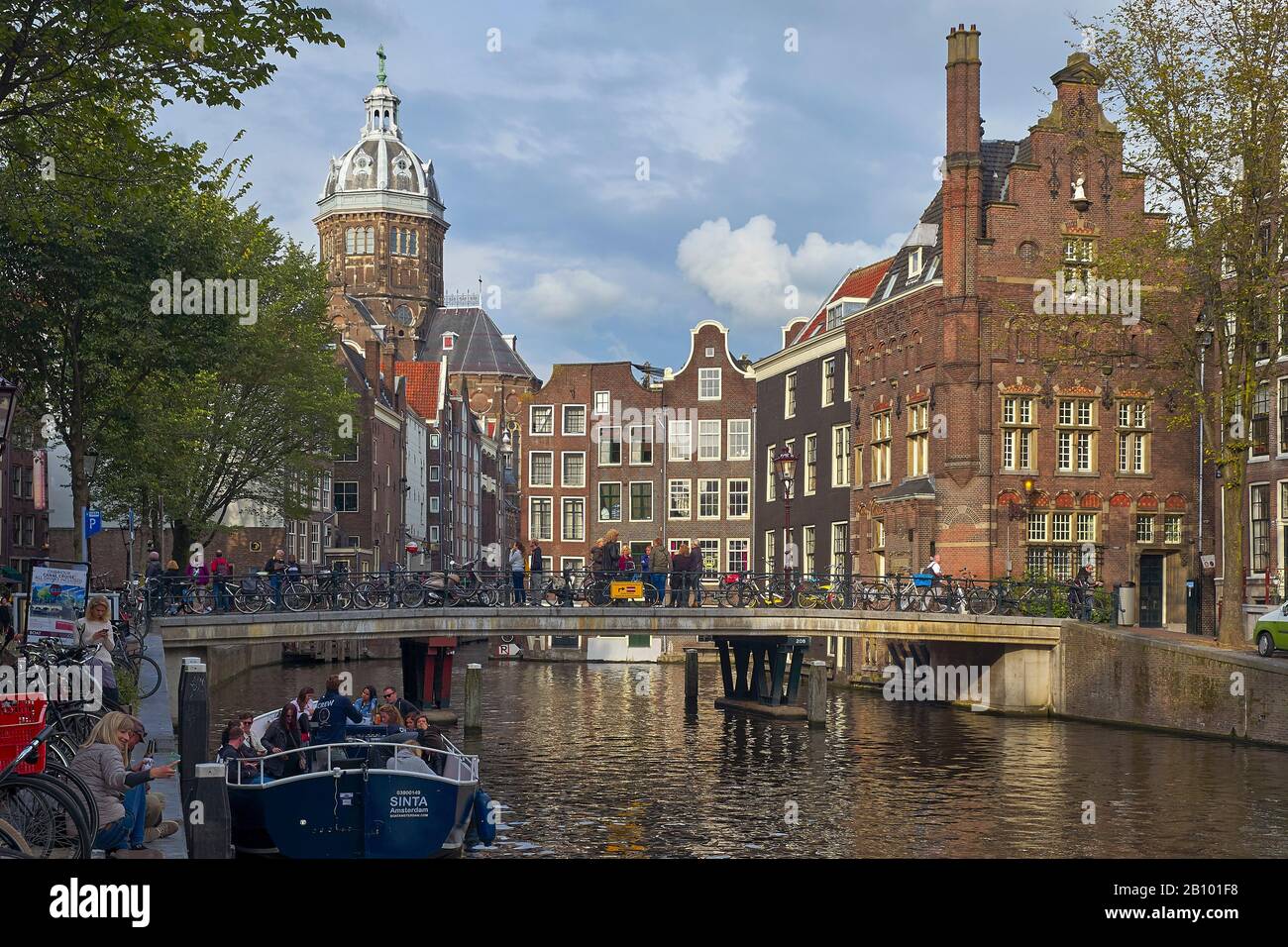 Canal con barche a St. Nicolaskirche, Amsterdam, Olanda del Nord, Paesi Bassi Foto Stock