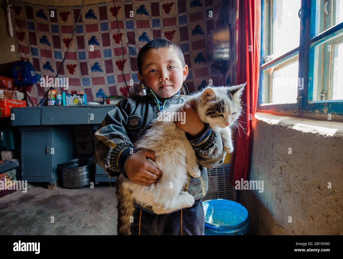 I bambini dello xinjiang remoto hanno pochissime possibilità e gli animali domestici sono la loro principale fonte di intrattenimento. Foto Stock